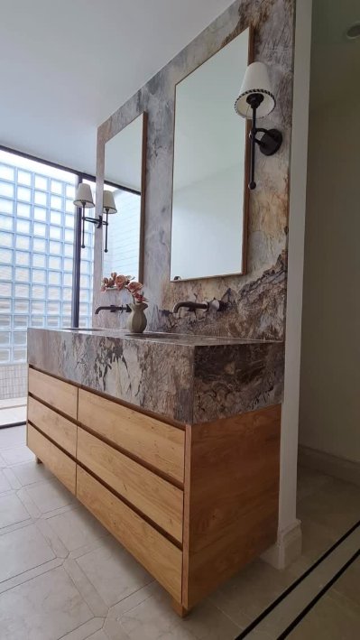 Stone and marble vanity with timber drawers and wall sconces
